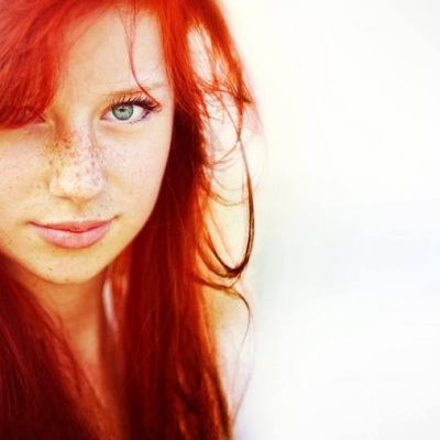 She has long red hair and she has freckles. 