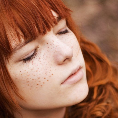 She has long red straight hair and she has freckles. 